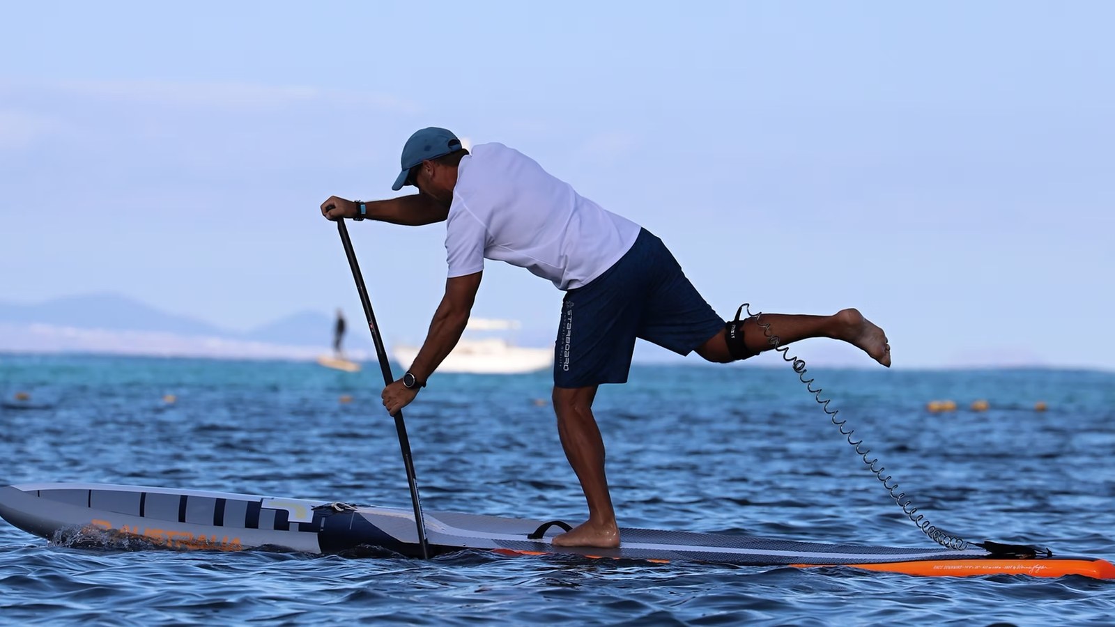 Jan Šrámek na závodním paddleboardu, stojí bosou nohou na prkně a druhou nohu má zvednutou za sebou